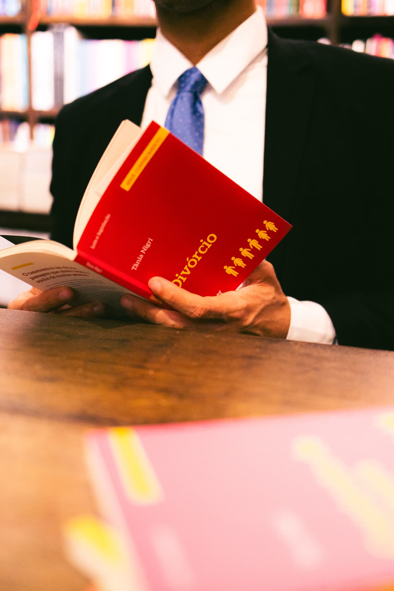 Advogado Douglas Aleixo lendo um livro sobre divórcio em uma livraria